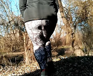 Plumper Mummy with massive booty in stretch pants urinating outdoors while standing doggie